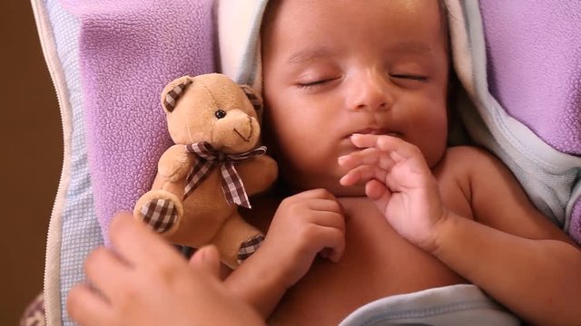 Teddy bear with sleeping newborn baby boy 