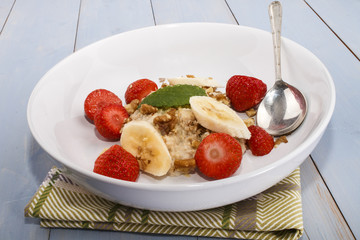 healthy breakfast with oatmeal, walnut, strawberry and mint leaf