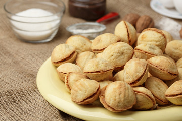 homemade cookies shaped nuts with cream boiled condensed milk on wooden table. Rustic style