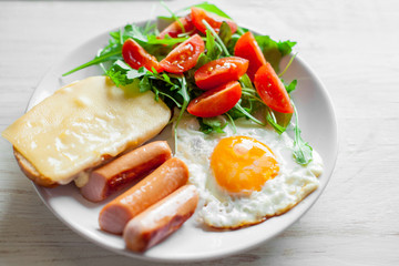 Breakfast which includes eggs, sausages, salad and toast with cheese