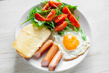 Breakfast which includes eggs, sausages, salad and toast with cheese