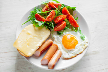Breakfast which includes eggs, sausages, salad and toast with cheese