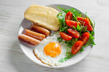 Breakfast which includes eggs, sausages, salad and toast with cheese