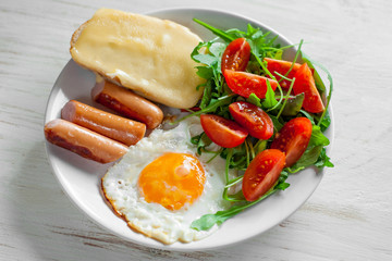 Breakfast which includes eggs, sausages, salad and toast with cheese