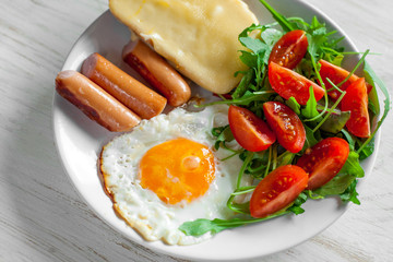 Breakfast which includes eggs, sausages, salad and toast with cheese