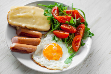 Breakfast which includes eggs, sausages, salad and toast with cheese