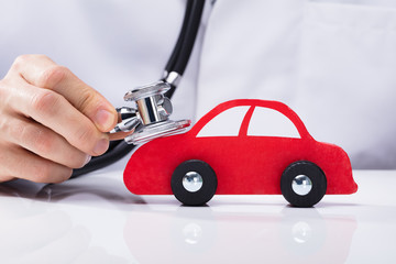 Doctor Examining Car With Stethoscope