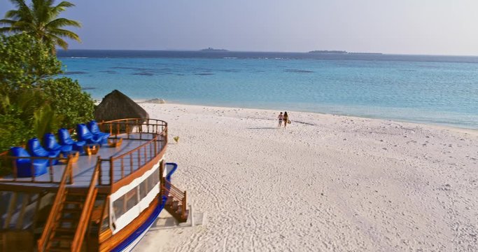 Aerial drone view of mother and son on the beach in the Maldives