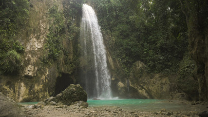 Waterfall in green forest in jungle. Beautiful waterfall in the mountains. Tropical rain forest with waterfall. Philippines, Cebu. Travel concept.