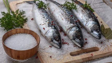 Salted mackerel on a cutting board with spices