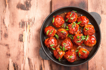 Meatballs in sweet and sour tomato sauce. Homemade roasted beef meatballs in cast-iron skillet