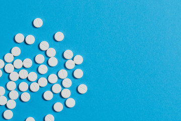 Medication white round tablets arranged abstract isolated on blue color background. Aspirin pills...