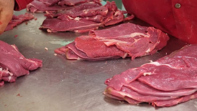 Butcher prepares beef slices for sale
