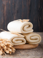 Puff pastry dough. Homemade raw puff pastry dough on a  table. Folded dough with wheat spikelets. 
