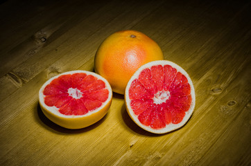 Grapefruit whole and halves on wooden background