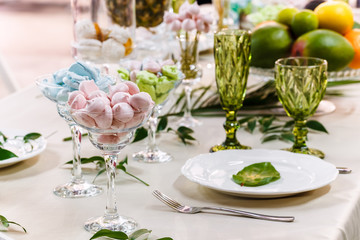 Festive table, decorated with vases, fruits and pastries.