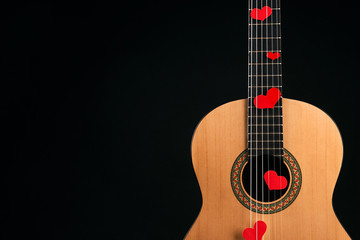 Red hearts on the strings of a guitar