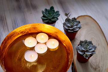 Golden bowl with water in which floating candles. Interior decoration for a relaxed atmosphere