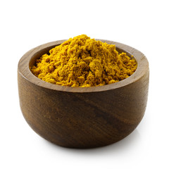 Curry powder in dark wood bowl isolated on white.