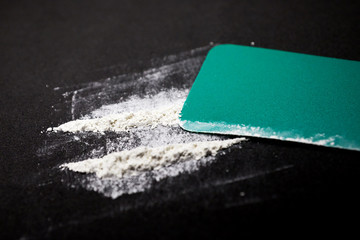 drug use, people, addiction and substance abuse concept. Rolled banknote, two lines cocaine on...