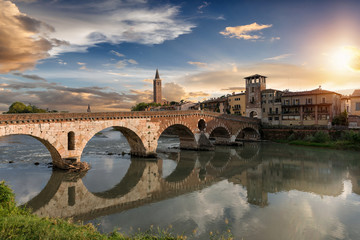 Die Ponte Pietra Brücke in Verona, Italien, bei Sonnenuntergang - obrazy, fototapety, plakaty