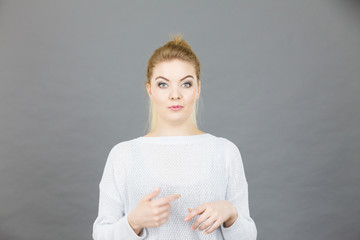 Confused young blonde woman gesturing with hands
