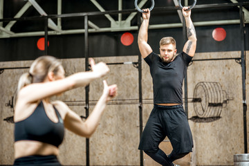Naklejka na ściany i meble Young athletic couple training in the crossfit gym