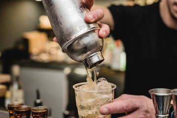 Barman schenkt een cocktail in het glas
