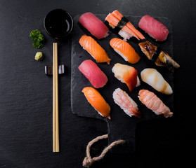 Sushi Set sashimi served on stone slate with dark background