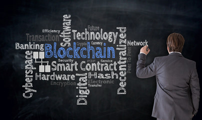 Businessman writes Blockchain cloud on blackboard Concept