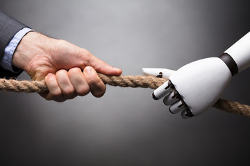 Businessperson And Robot Playing Tug Of War
