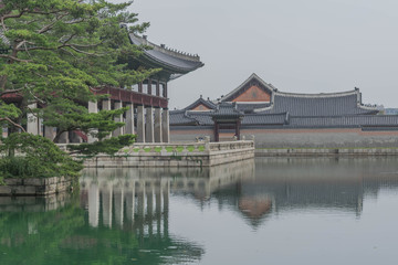 Fototapeta premium Small lake with a reflection of rooftops, and other historical buildings, at Gyeongbokgung Palace, Seoul, South Korea