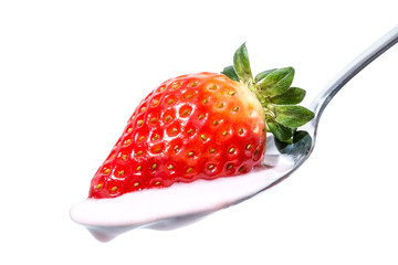Strawberry on a spoon with strawberry pink yogurt cream close-up isolated on white background