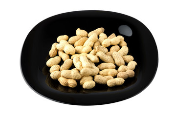 Fried peanuts in shell. Peanut in a shell on a black plate close-up.
