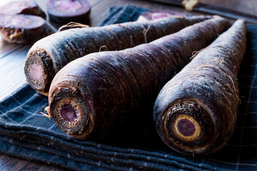 Purple Carrots on Dark Wooden Surface.