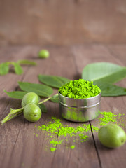Indian Holi festival of colours or colors. Bright colors for holi festival. Green holi paint in a bow (cup) on a table. Close up with copy space