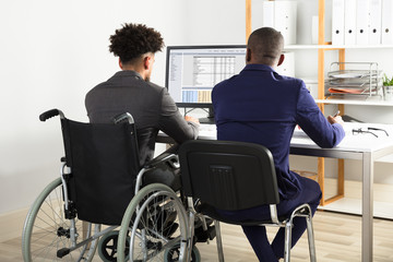 Physically Impaired Businessman With His Partner Working