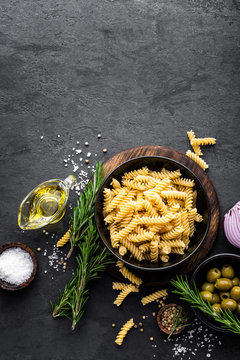 Pasta and ingredients for cooking on black background, top view. Italian food