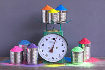 Festival of colors. Bright colors for holi festival. Colorful holi paint in a metal cups on scales...