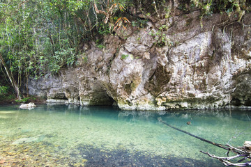 Fototapeta na wymiar The Bladen River flows under limestone cliffs in one of the most biodiverse and untouched pieces of land in Central America. Photographed in central Belize.
