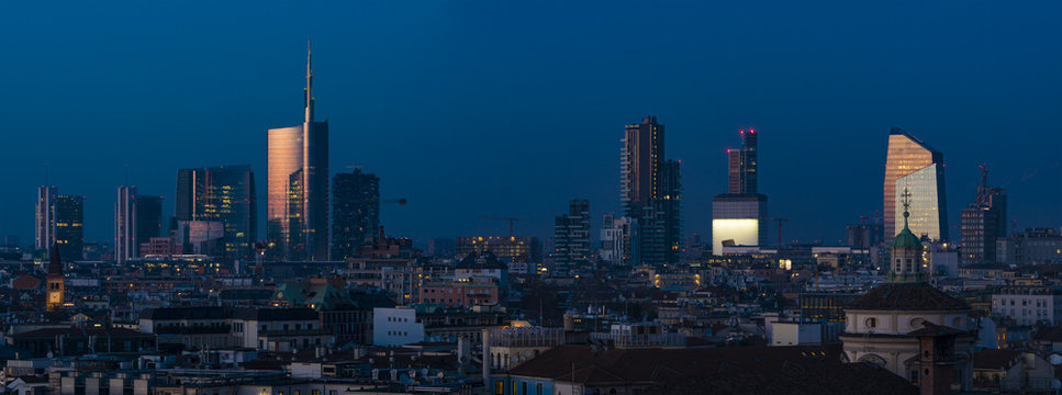 Milan (Italy) skyline by night; cityscape with new Porta Nuova skyscrapers, panoramic view from the rooftop of Duomo Milan cathedral.