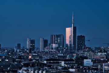 Milan (Italy) skyline by night; cityscape with new Porta Nuova skyscrapers, panoramic view from the rooftop of Duomo Milan cathedral.