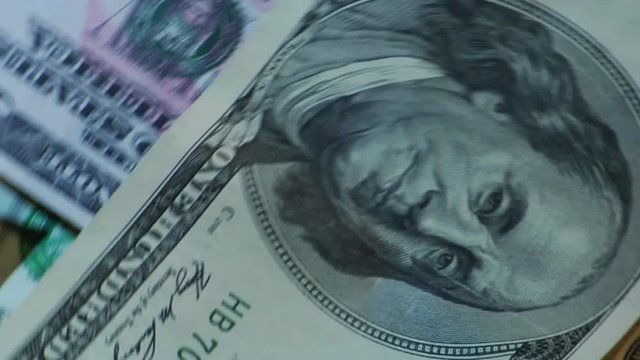 Money of different countries are circling around a close-up loop