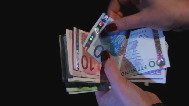 Hands consider monetary banknotes