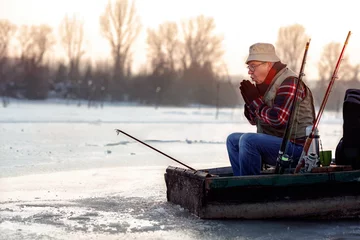 Photo sur Plexiglas Anti-reflet Pêcher man fishing on the frozen river in winter