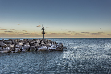 Post sitting on rocks in lake