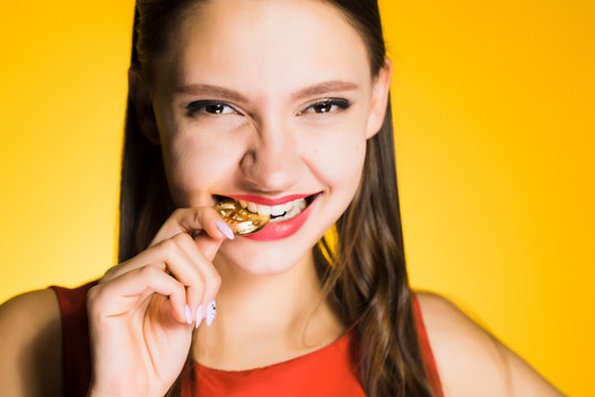 happy woman bites the crypt on a yellow background