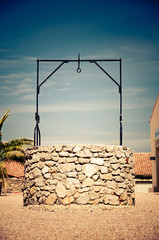 Fototapeta premium well with drinking water in harsh sunlight at noon in south france