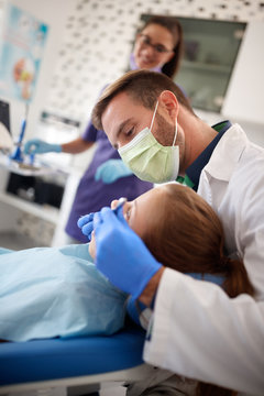 Dentist repairing girls tooth