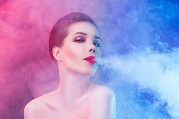 Smoking sexy young woman on red and blue background.